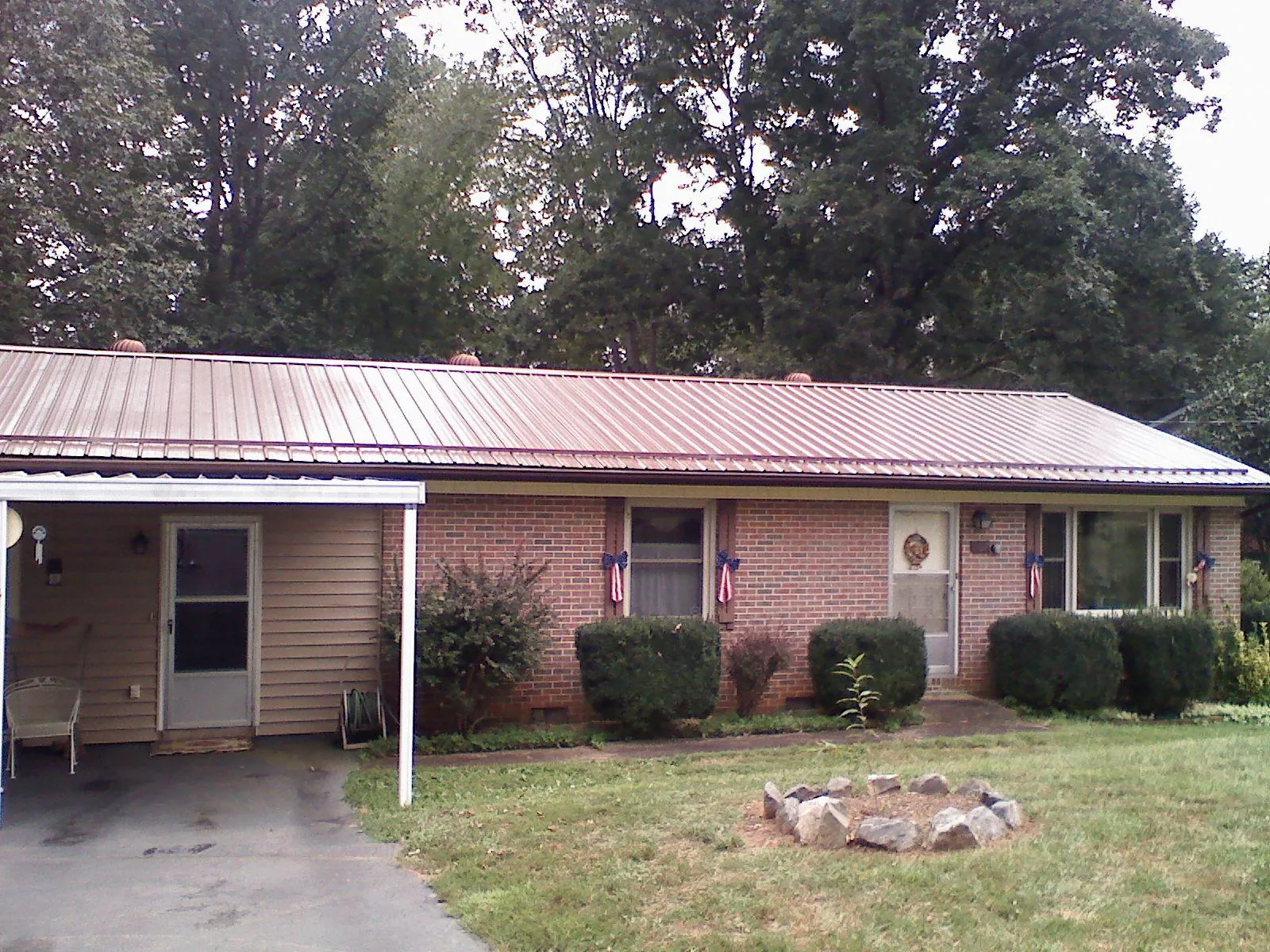 Bronze metal roof and carport on a brick ranch home — Roof Repair work by our crew in Stockton